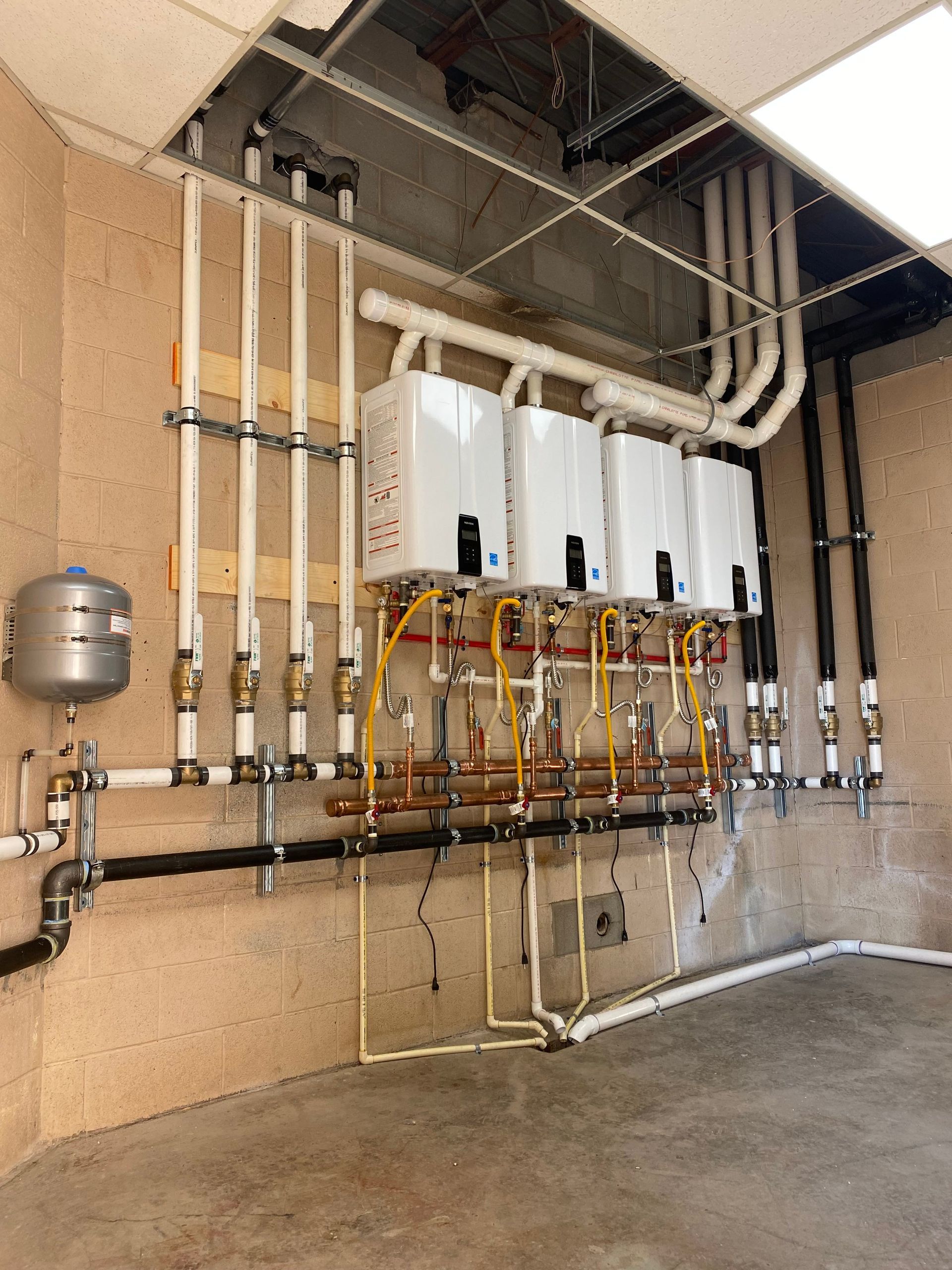 A row of water heaters are lined up in a room
