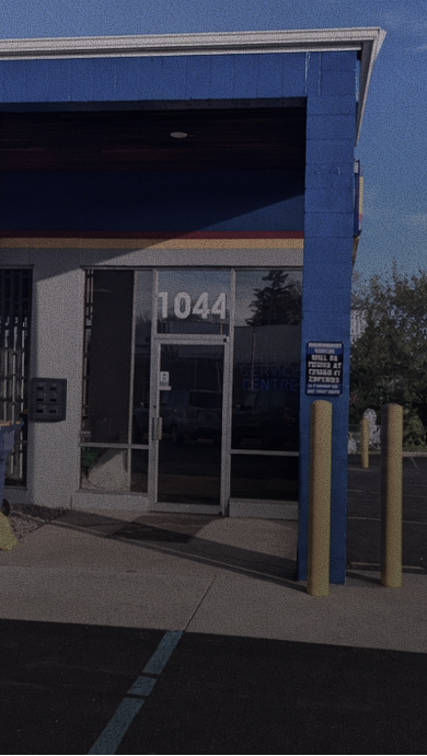 Storefront entrance with blue trim and glass door numbered 1044. | Heritage Service Centre