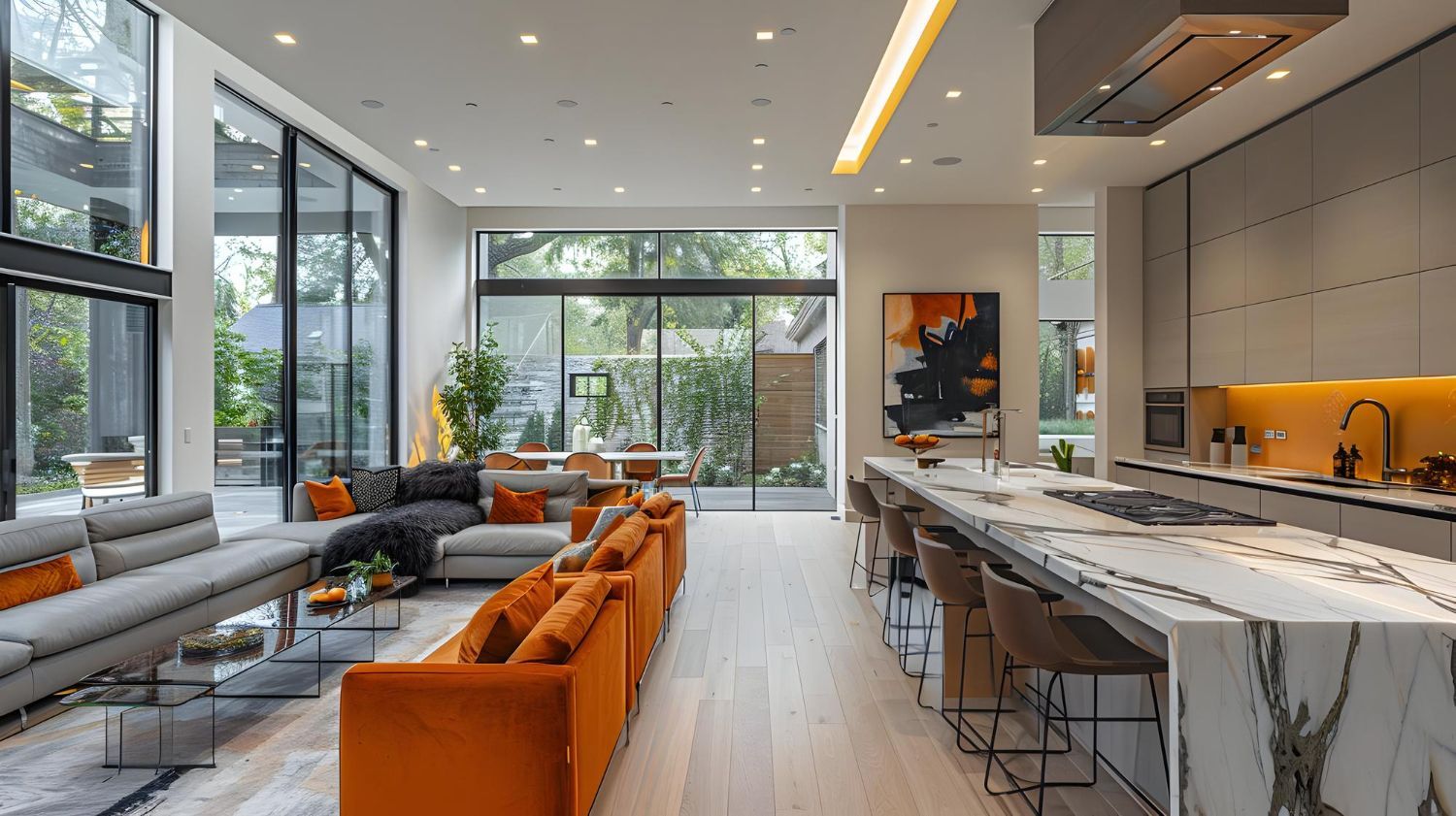 Modern open-plan living room and kitchen with orange seating, marble island, and large glass doors to a garden