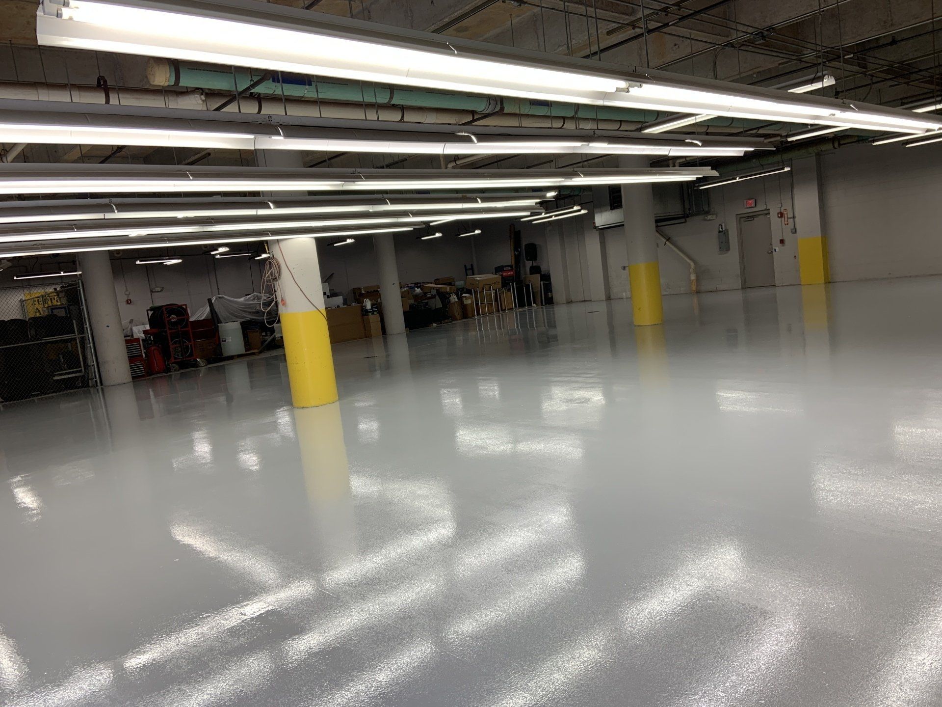 A large warehouse with a shiny floor and lots of lights.