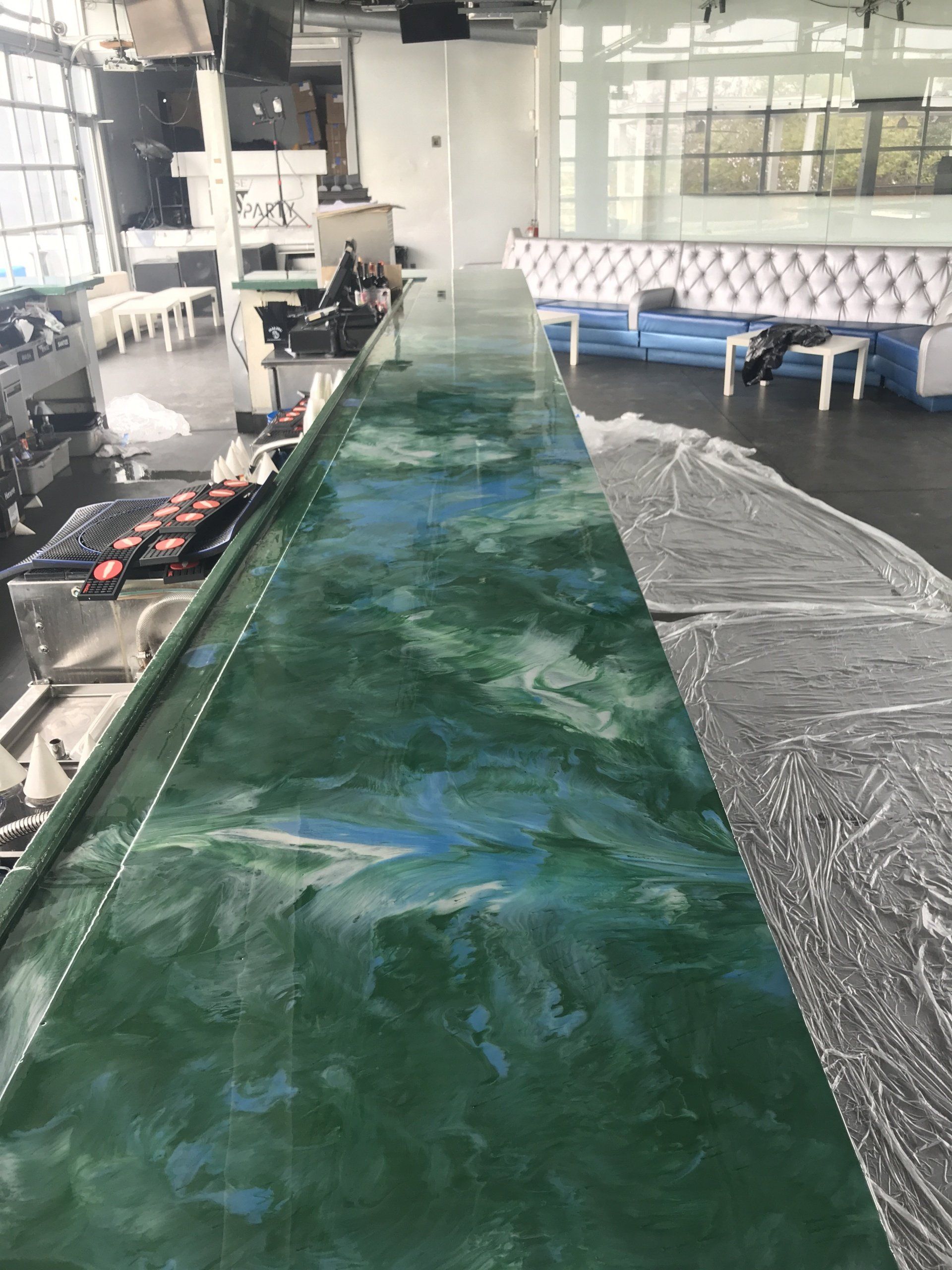 A long green counter top in a room with a lot of furniture.