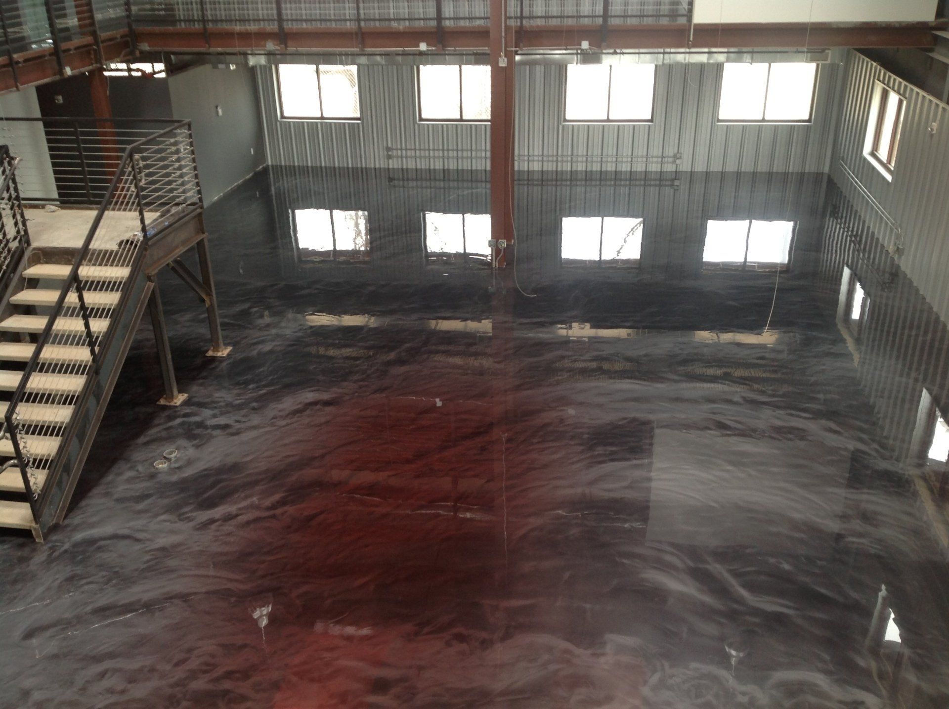 A large room with a staircase and a shiny floor.