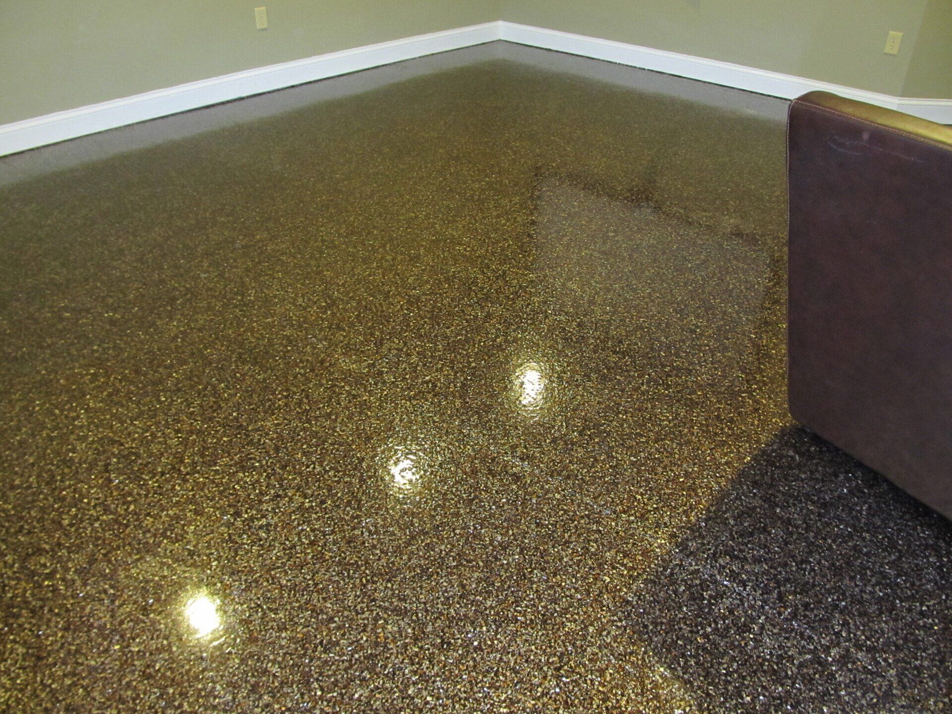 A living room with a couch and a shiny floor