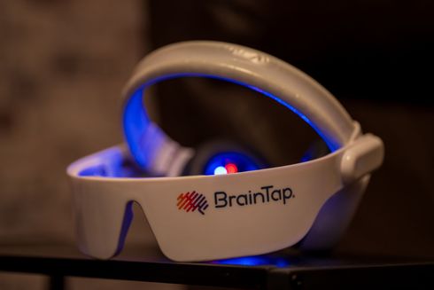 BrainTap headset glowing blue on a dark surface