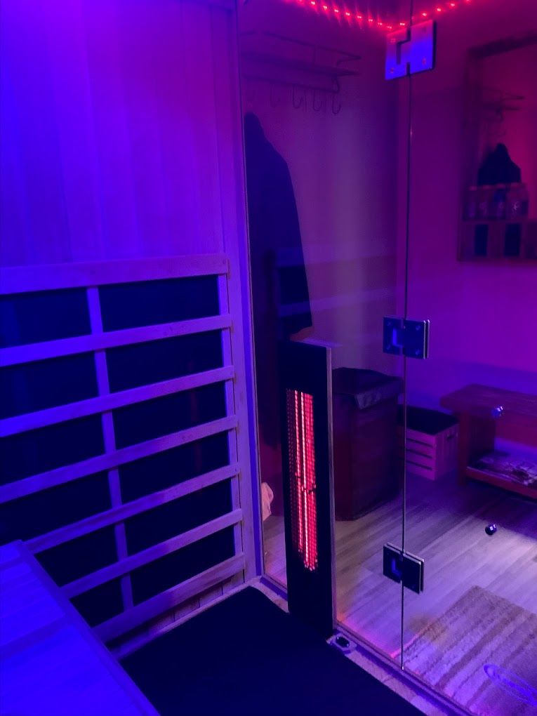Purple-lit room with mirrored wall panels, a black heater, and a slatted white bench or railing.