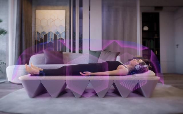 Person lying on a purple yoga mat under a translucent pink cover in a modern room.