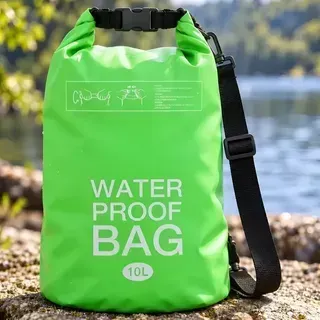 Bolsa estanca impermeable de color verde brillante con correa negra, de pie al aire libre sobre una superficie rocosa.