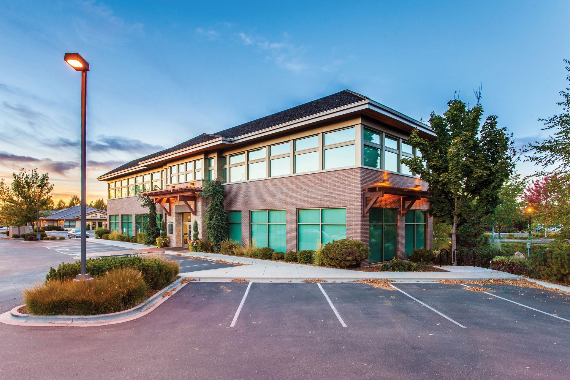 A large building with a lot of windows and a parking lot in front of it