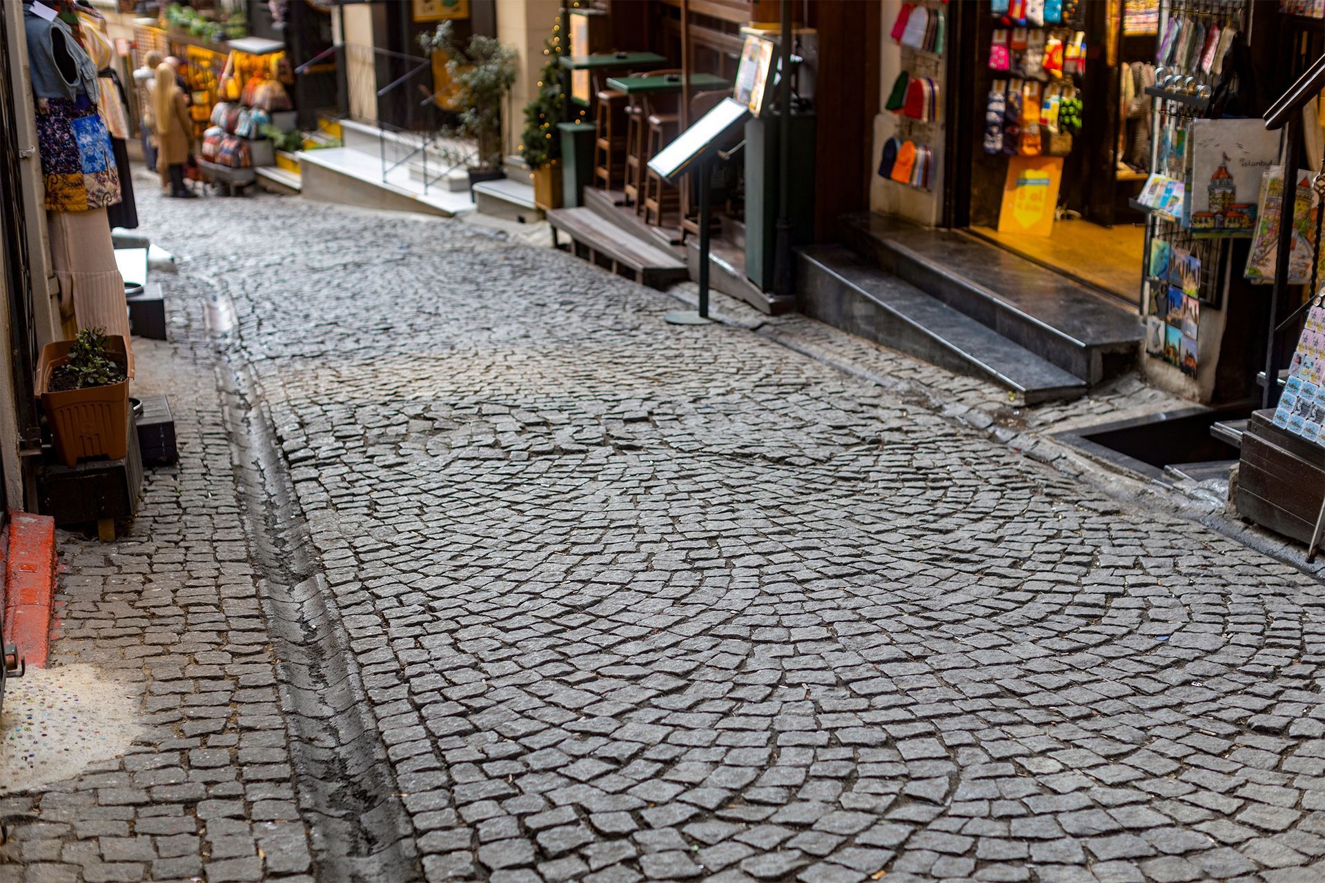 A cobblestone street with shops on both sides of it