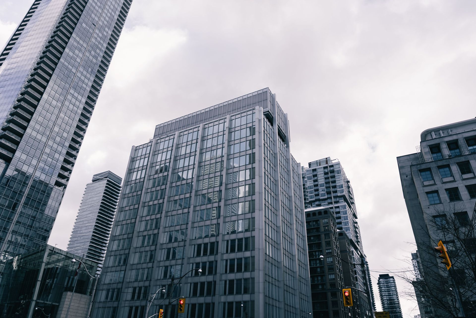Tall modern office buildings viewed from below on an overcast city street.