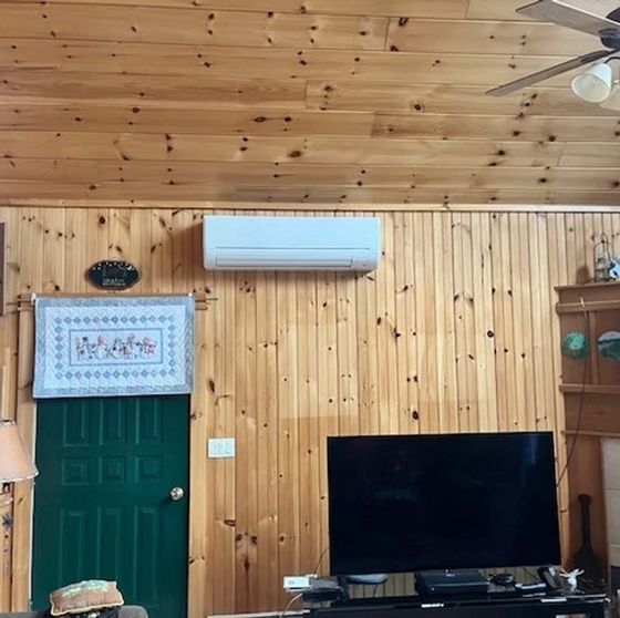 A living room with wood paneling and a flat screen tv