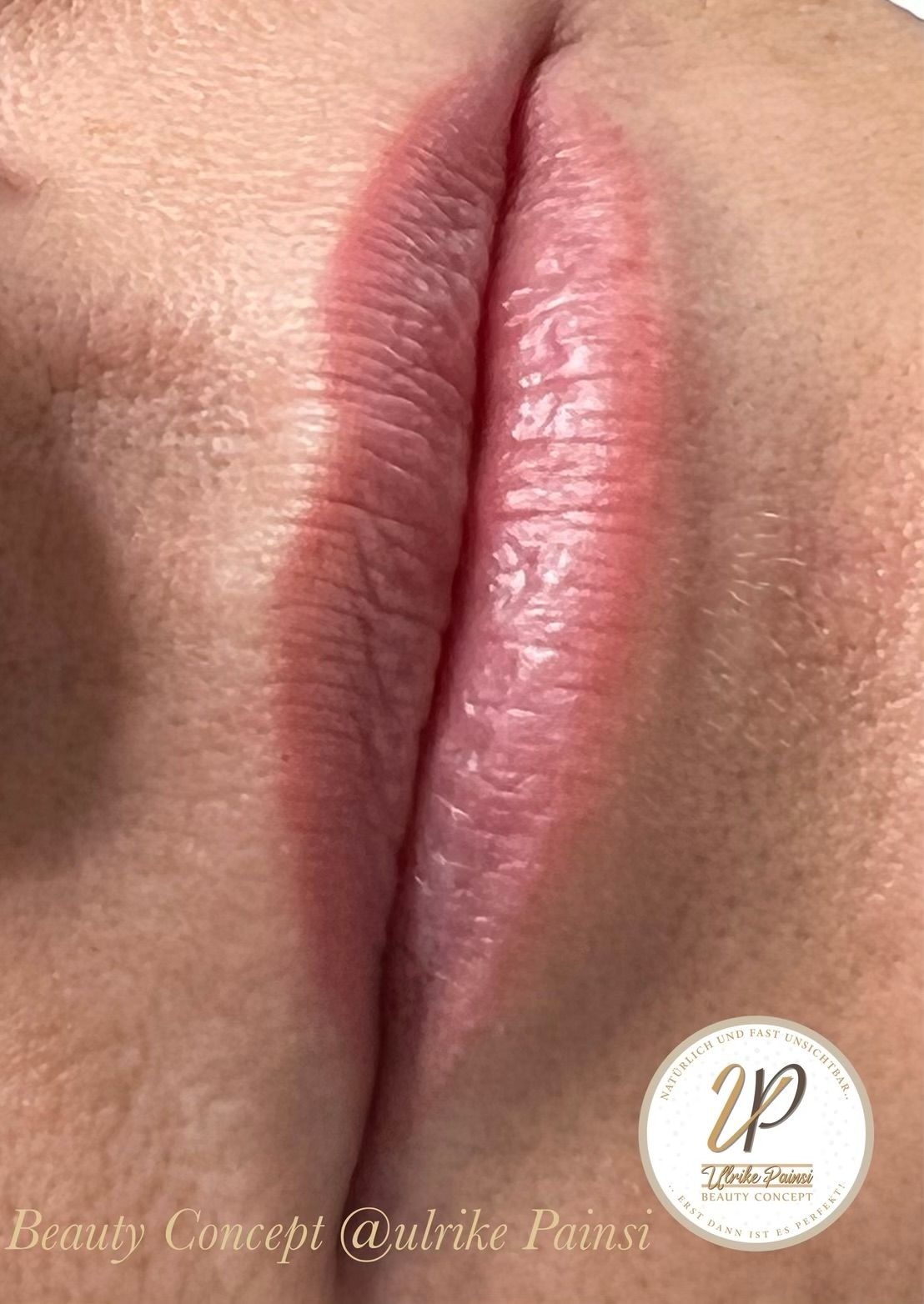 Nahaufnahme von natürlich rosafarbenen Lippen mit sanftem Glanz und einem kleinen Beauty-Wasserzeichen im Mundwinkel