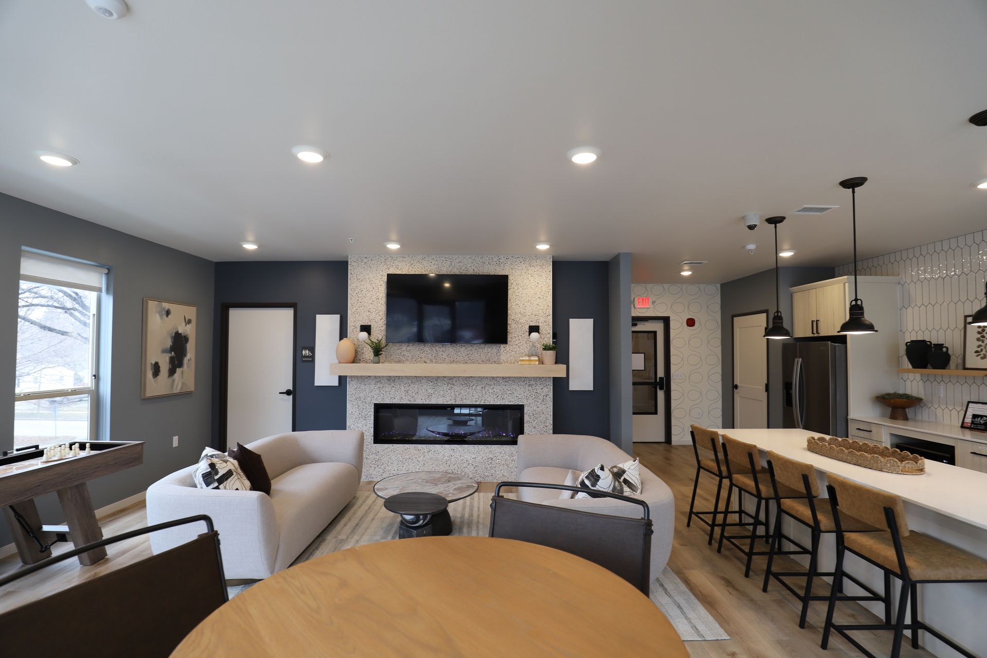 Living room with stone fireplace, wooden accents, TV, black armchair, and red paper lanterns.