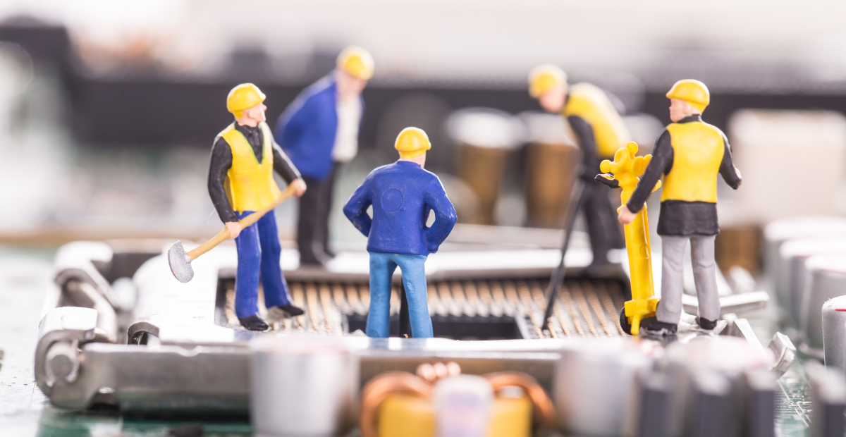 miniature figures working on hardware improvement