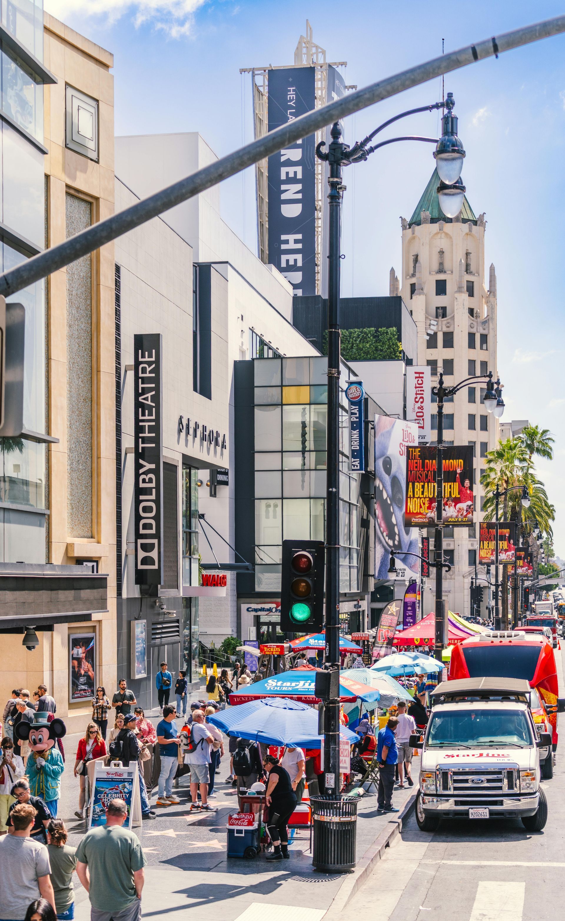 A busy city street with a lot of people walking down it.