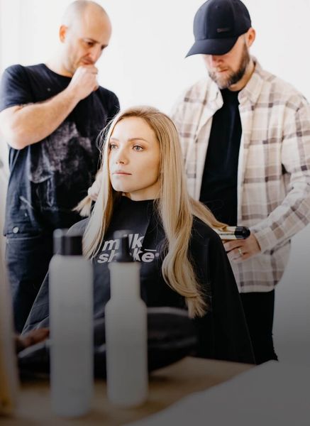 Un barbiere applica la crema da barba sulla barba di un cliente con un pennello.