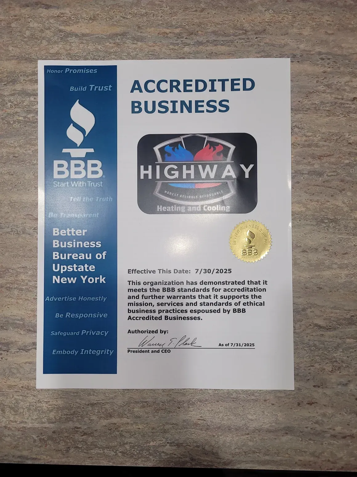 BBB accredited business certificate for Highway with blue sidebar and gold seal on a wood surface