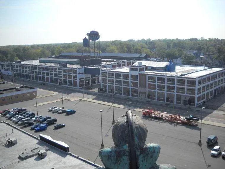 Aerial view of a modern office building with a parking lot and a water tower nearby