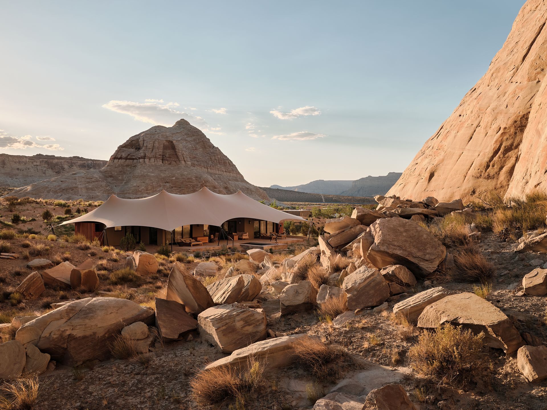 Amangiri among rocks, red cliffs, and a mountain under a clear sky
