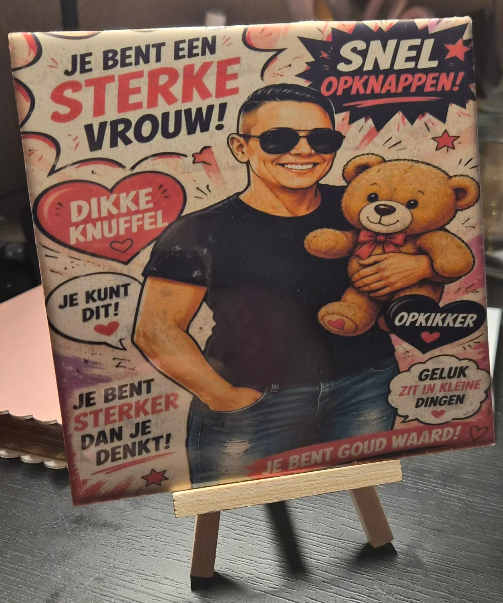 Schilderij op een ezel van twee lachende vrouwen met blond haar tegen een donkere achtergrond in caféstijl.