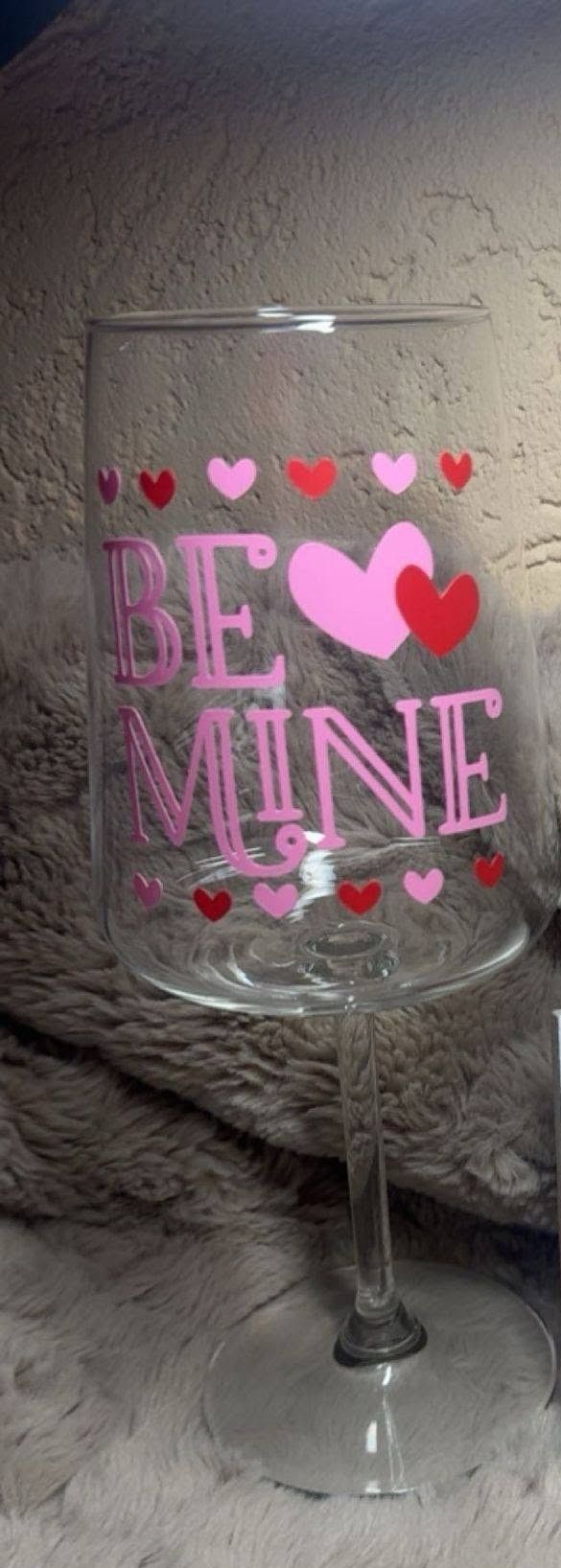 Wijnglas met roze hartjes en de tekst 