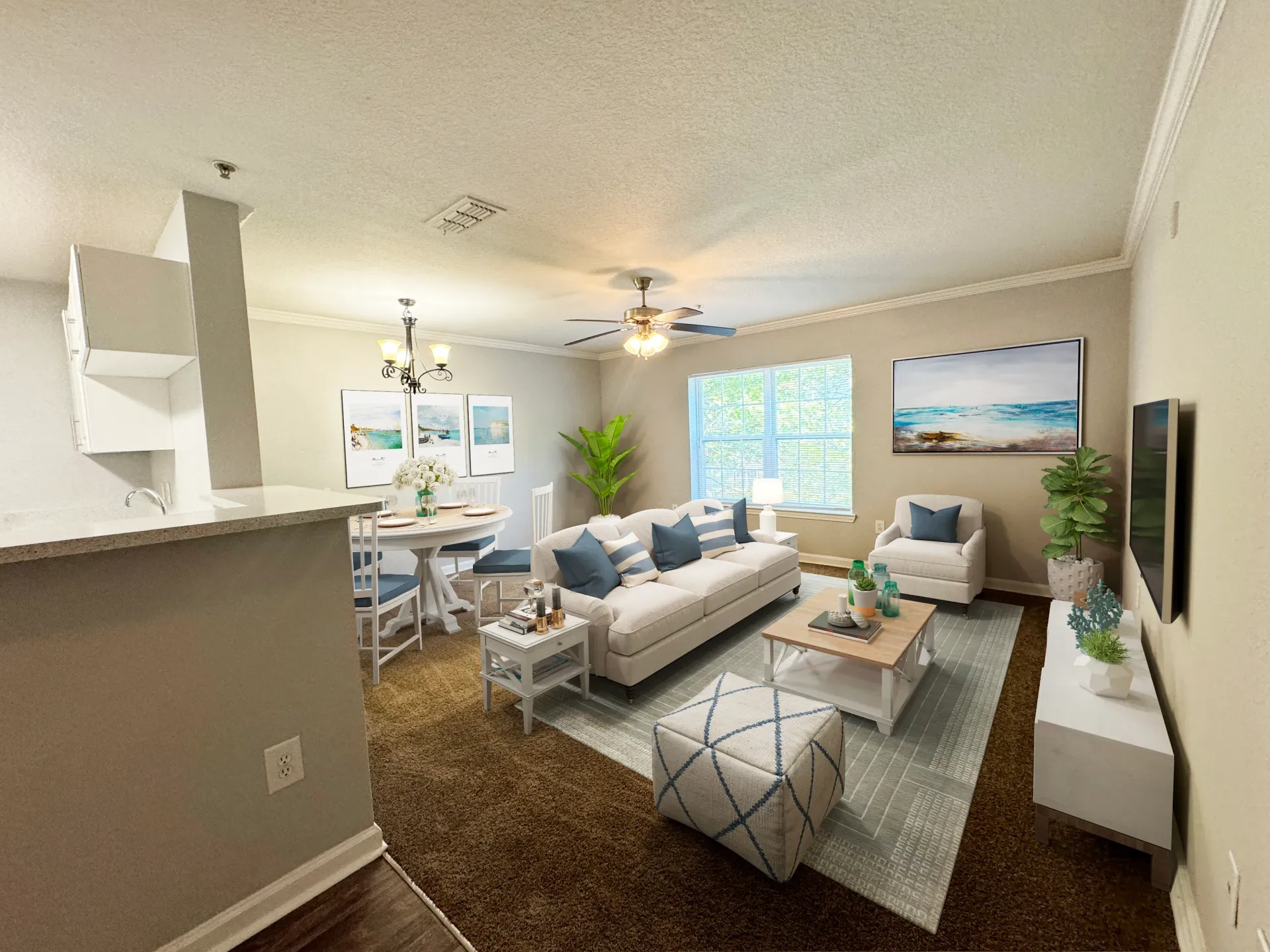 Living room and dining area with white furniture, blue accents, and beach-themed artwork.