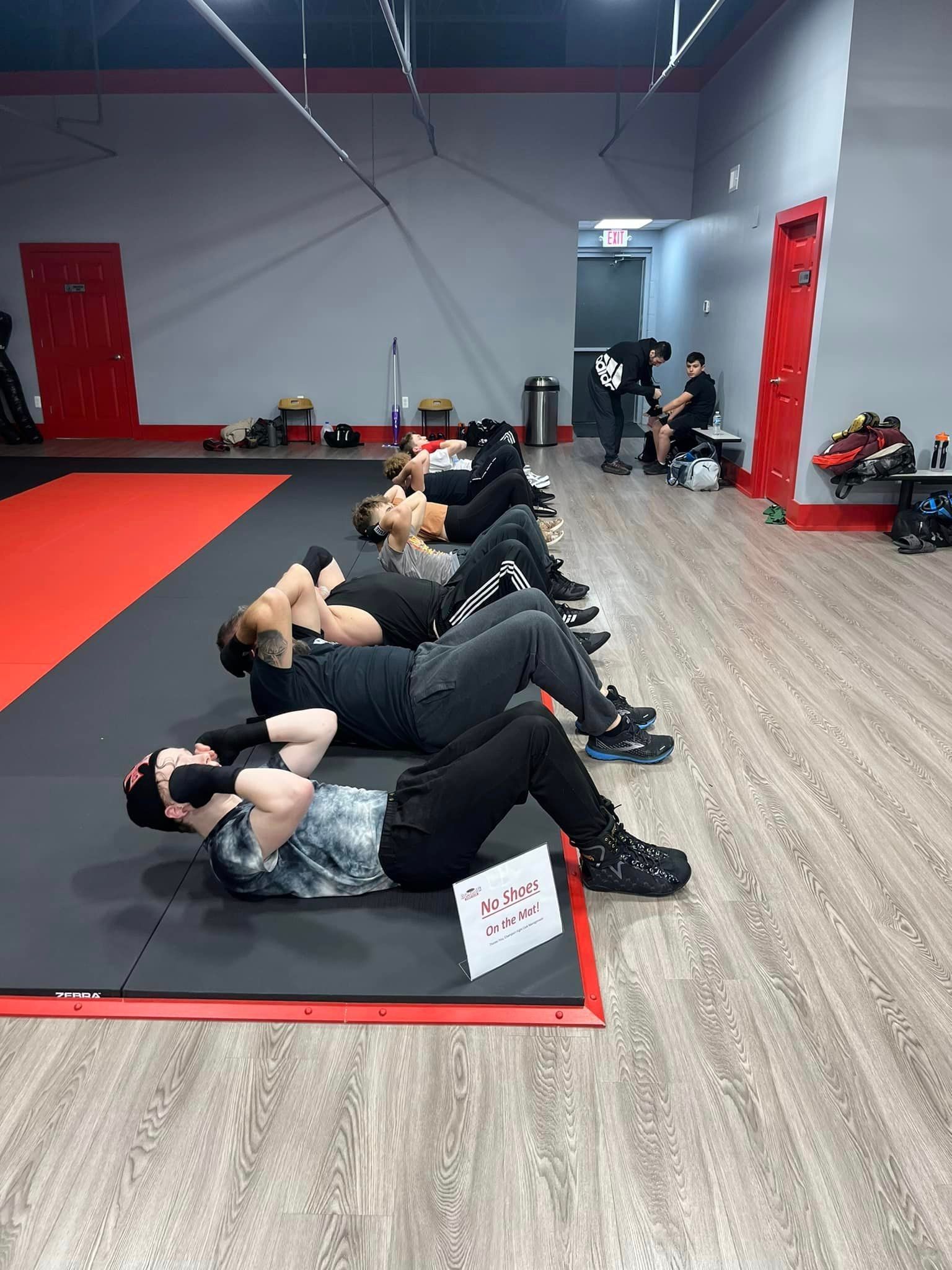 People working out and doing situps at champion boxing & fight club