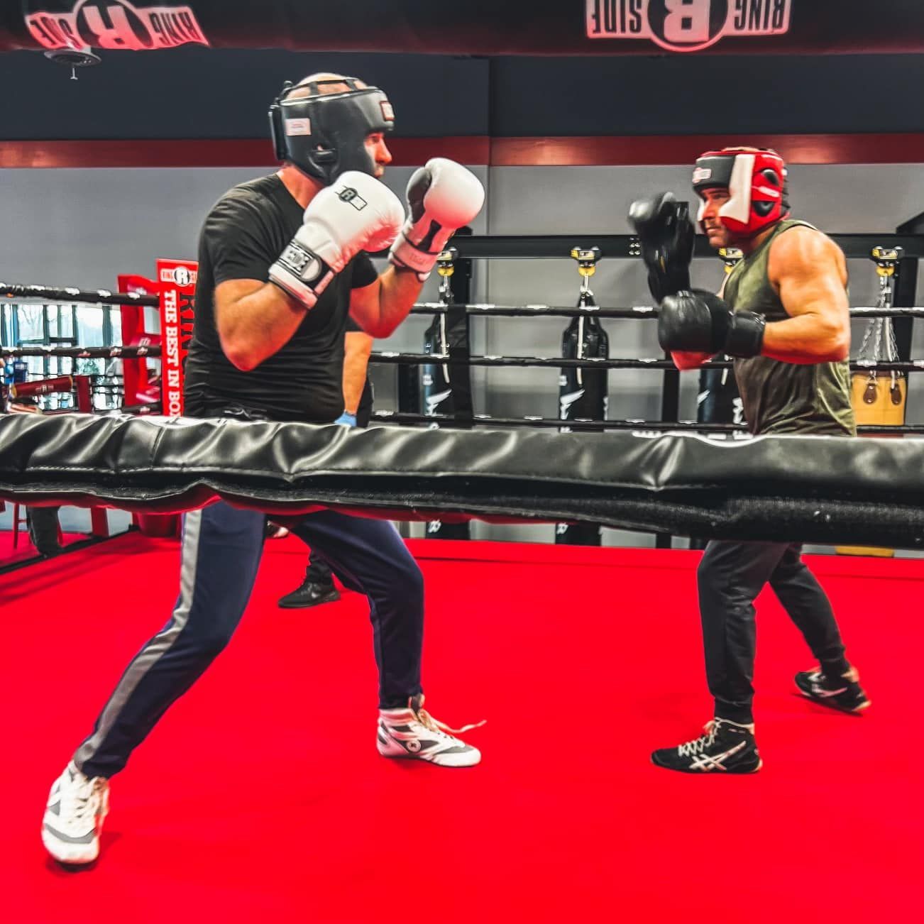 Two men in the ring boxing at champion boxing & fight club.