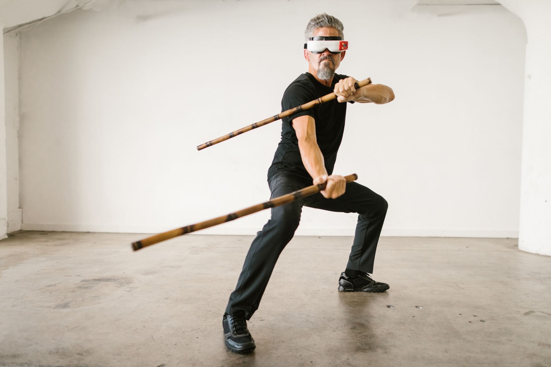 Man holding the Arnis/Kali sticks in a fighting stance