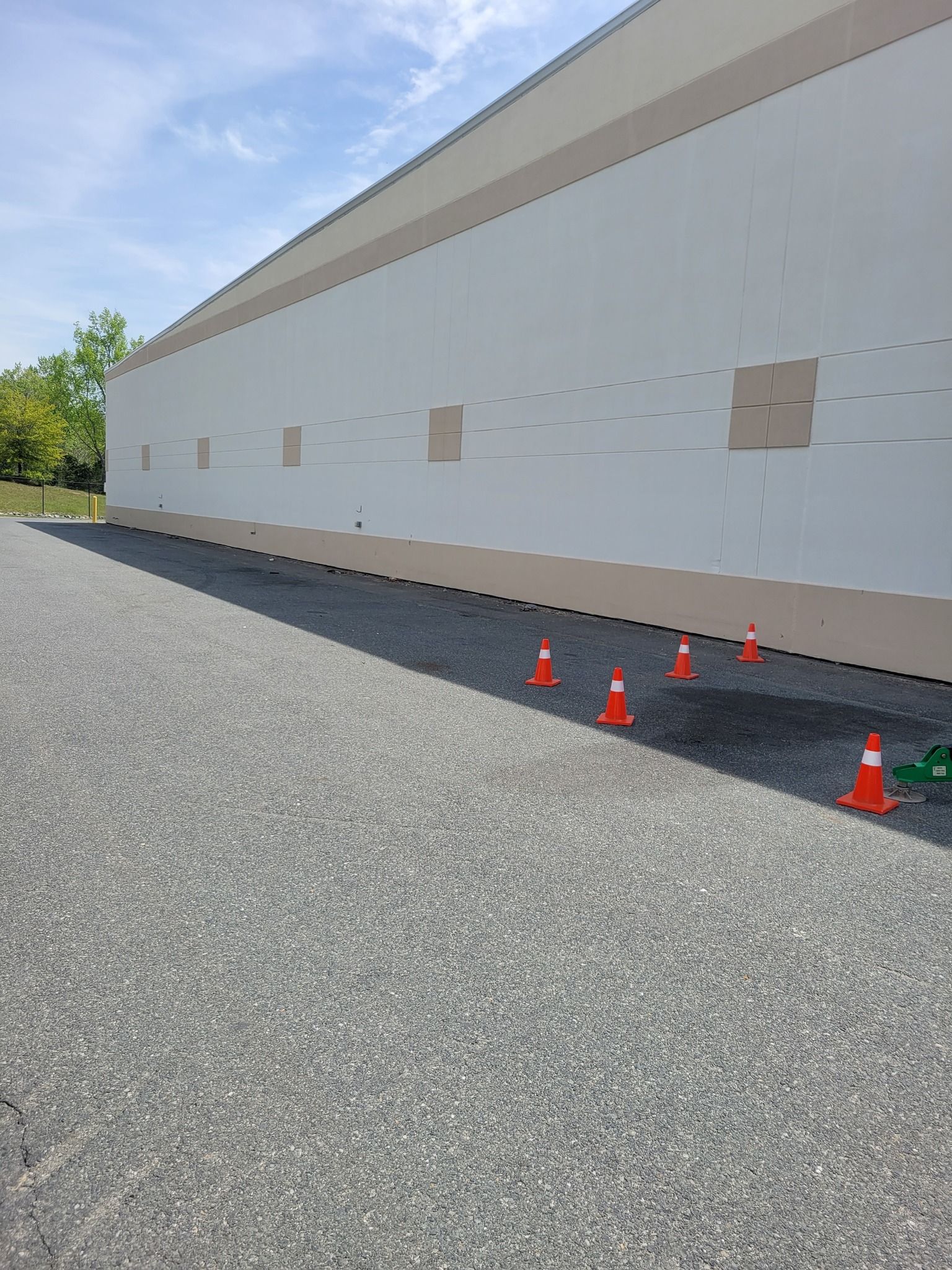 Exterior of a building with gravel and orange traffic cones.