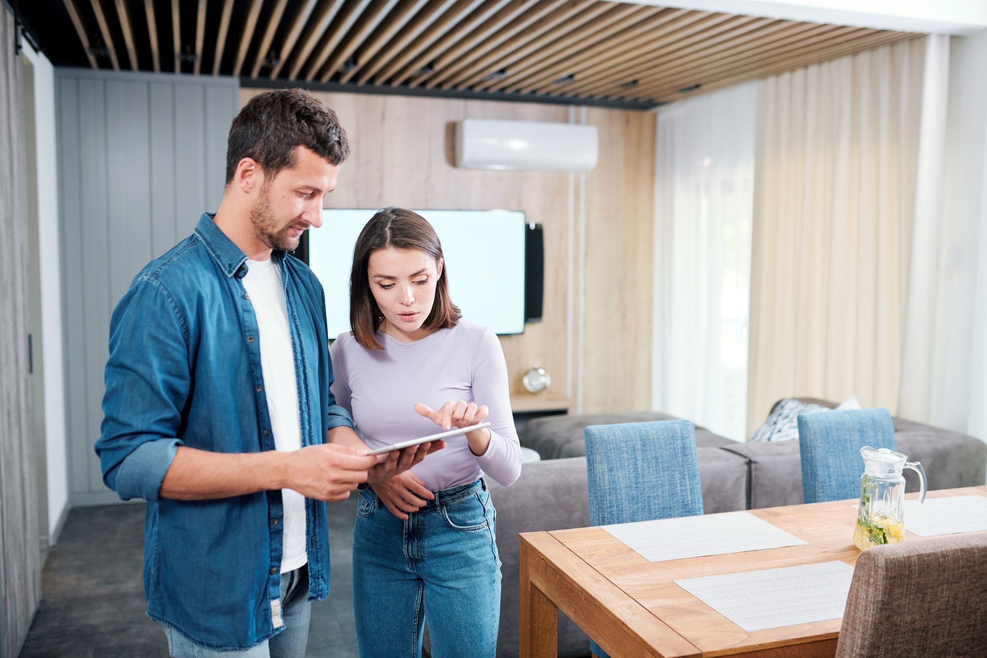 Two people reviewing a document in a modern apartment living room