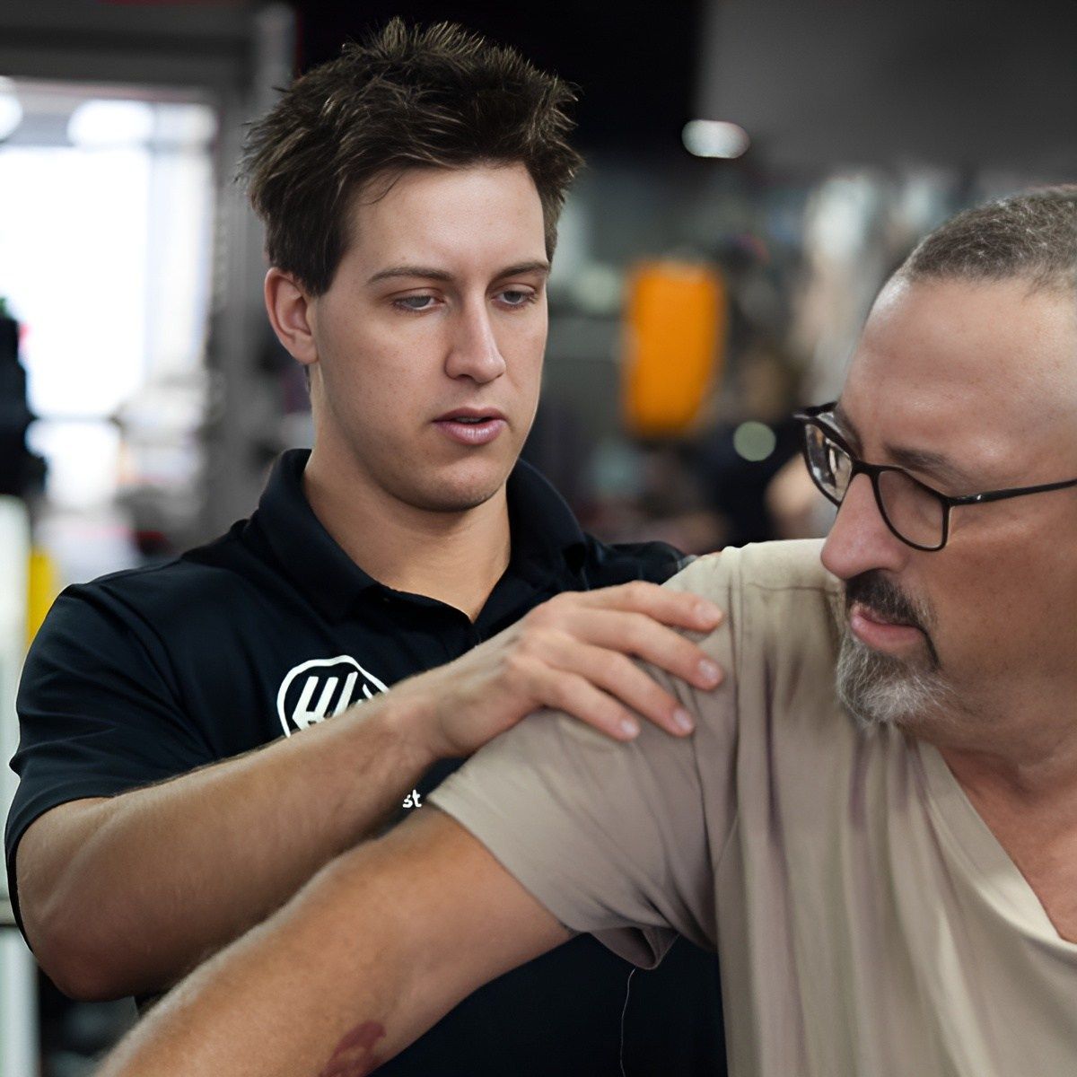 A Man Wearing Glasses and a Black Shirt With the Letter W on It — Health First Townsville In Townsville, QLD