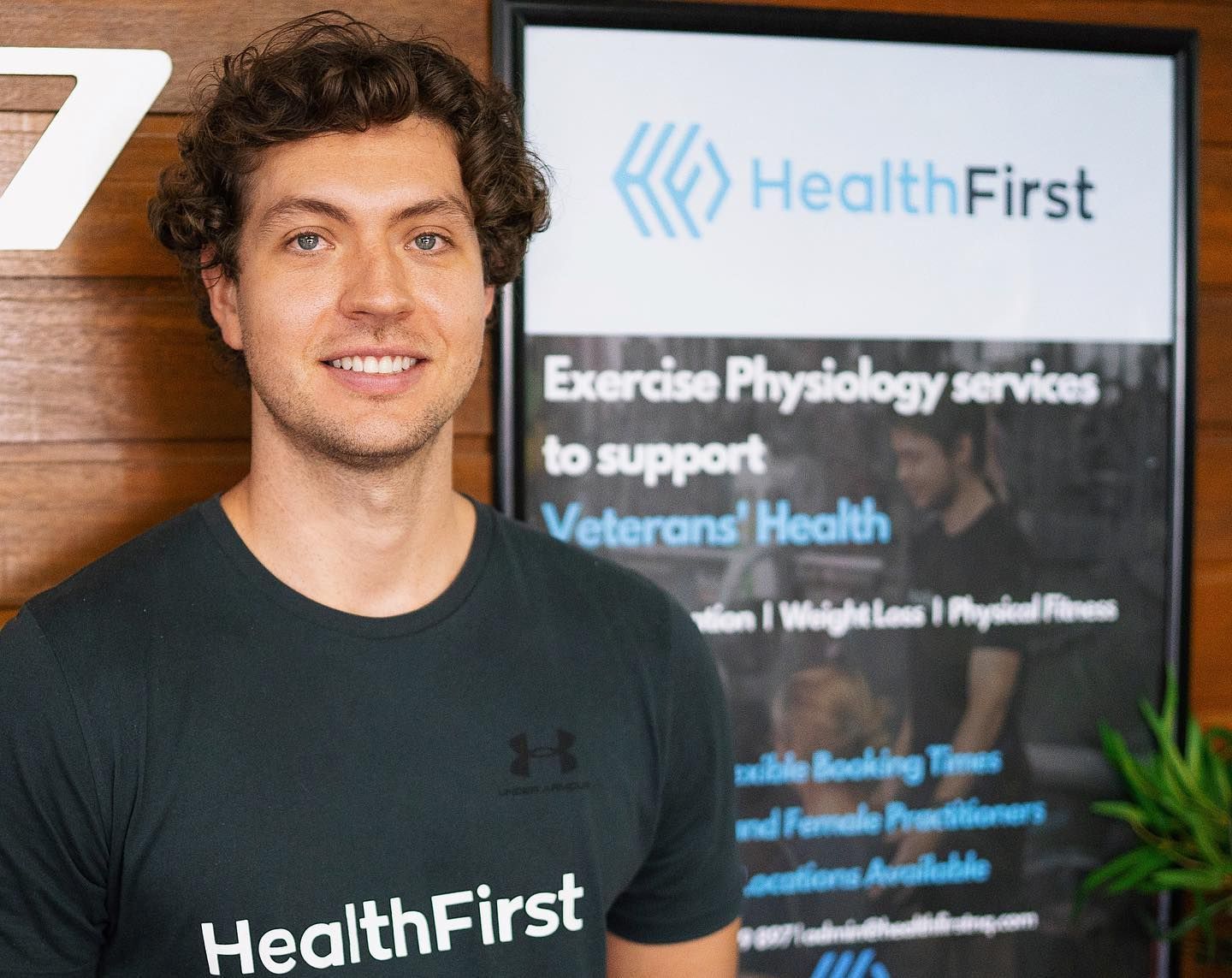 A Man is Standing in Front of a Health First Sign — Health First Townsville In Townsville, QLD