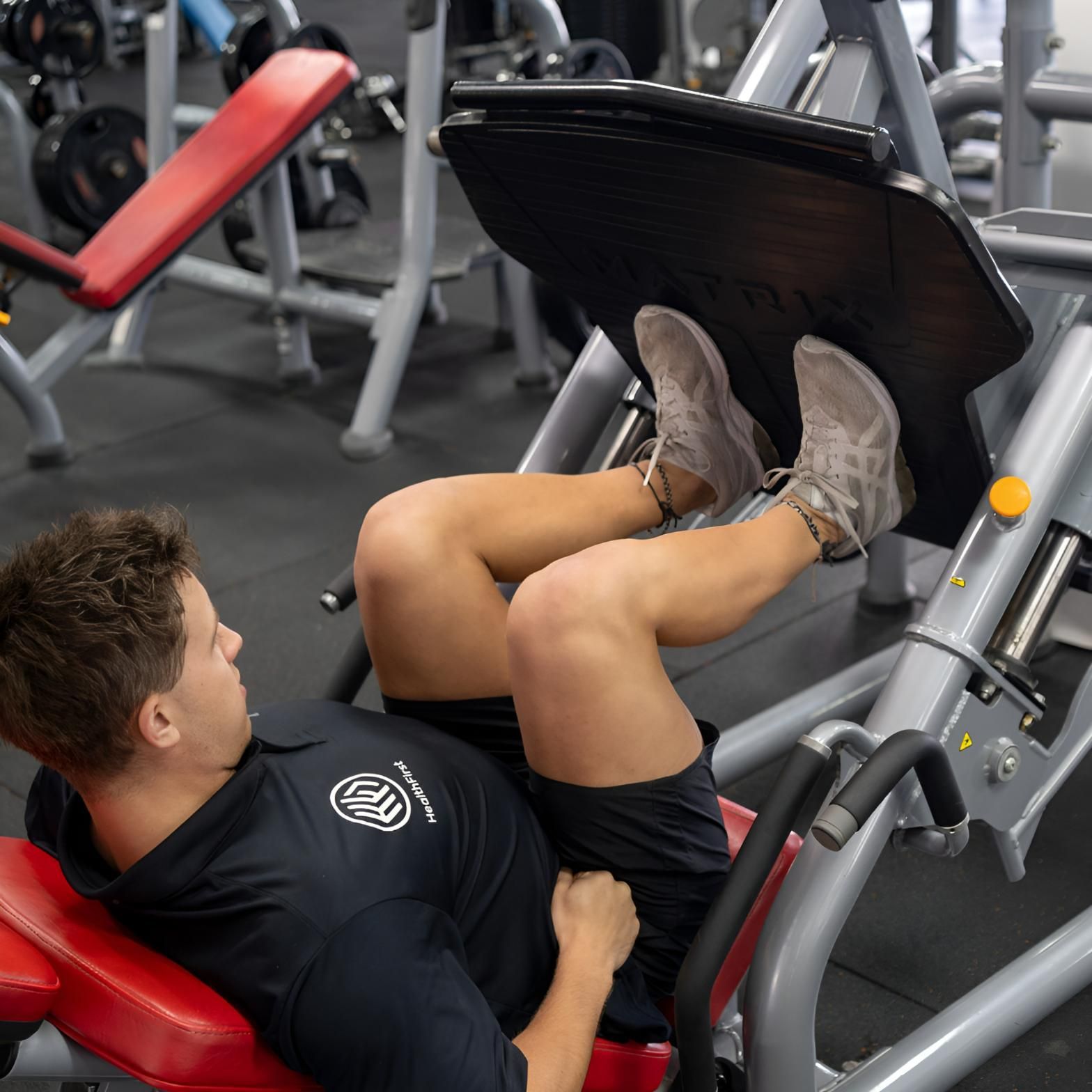 A Man is Using a Leg Press Machine in a Gym — Health First Townsville In Townsville, QLD
