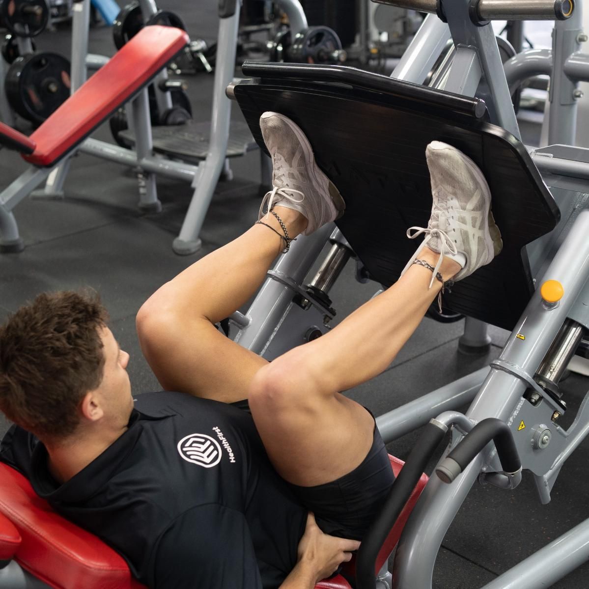 A Man is Using a Leg Press Machine in a Gym — Health First Townsville In Townsville, QLD