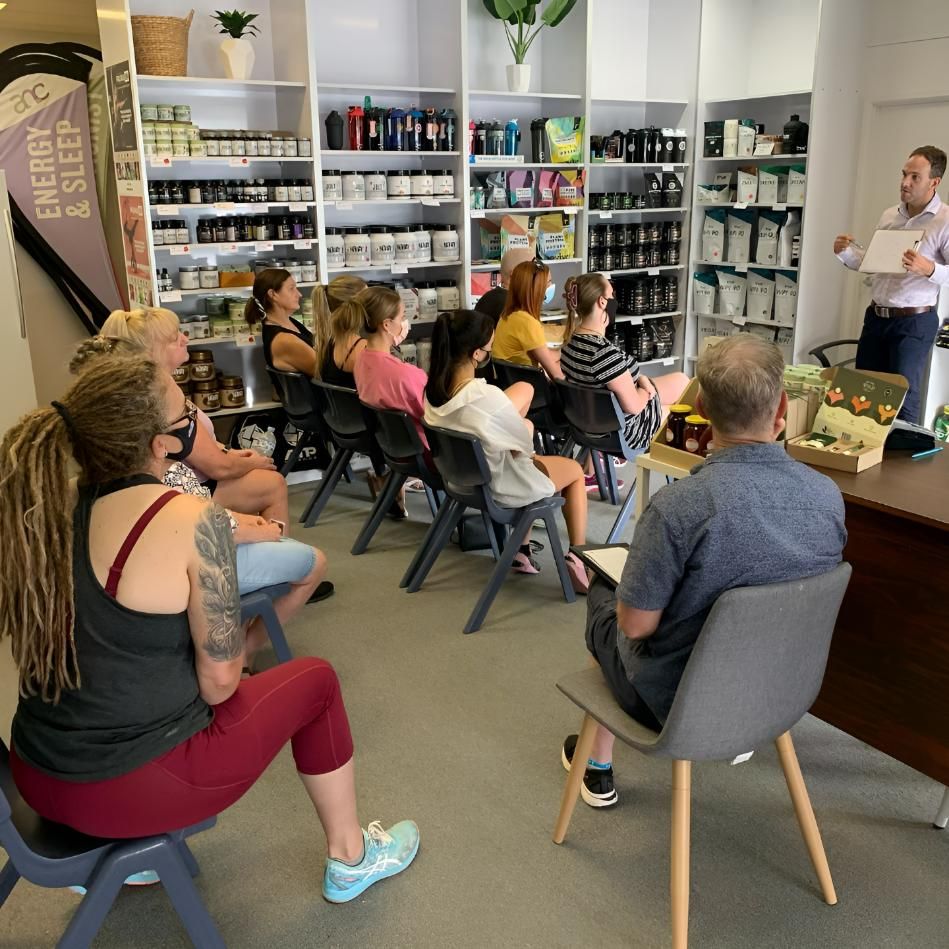 A Group of People Are Sitting in Chairs in Front of a Sign — Health First Townsville In Townsville, QLD