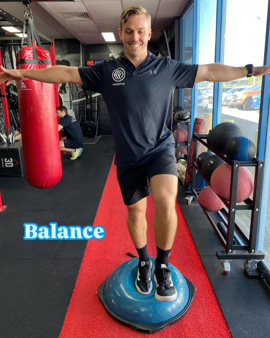 A Man is Sitting on a Machine in a Gym — Health First Townsville In Townsville, QLD