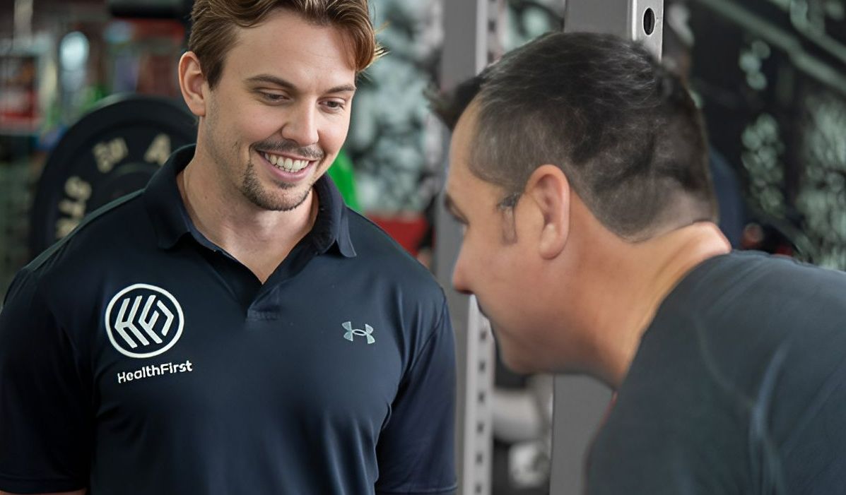 Two Men Are Talking to Each Other in a Gym — Health First Townsville In Townsville, QLD