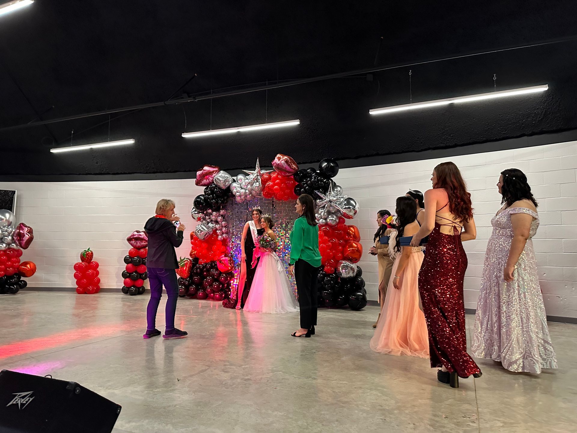 A group of women are standing in a room with balloons.