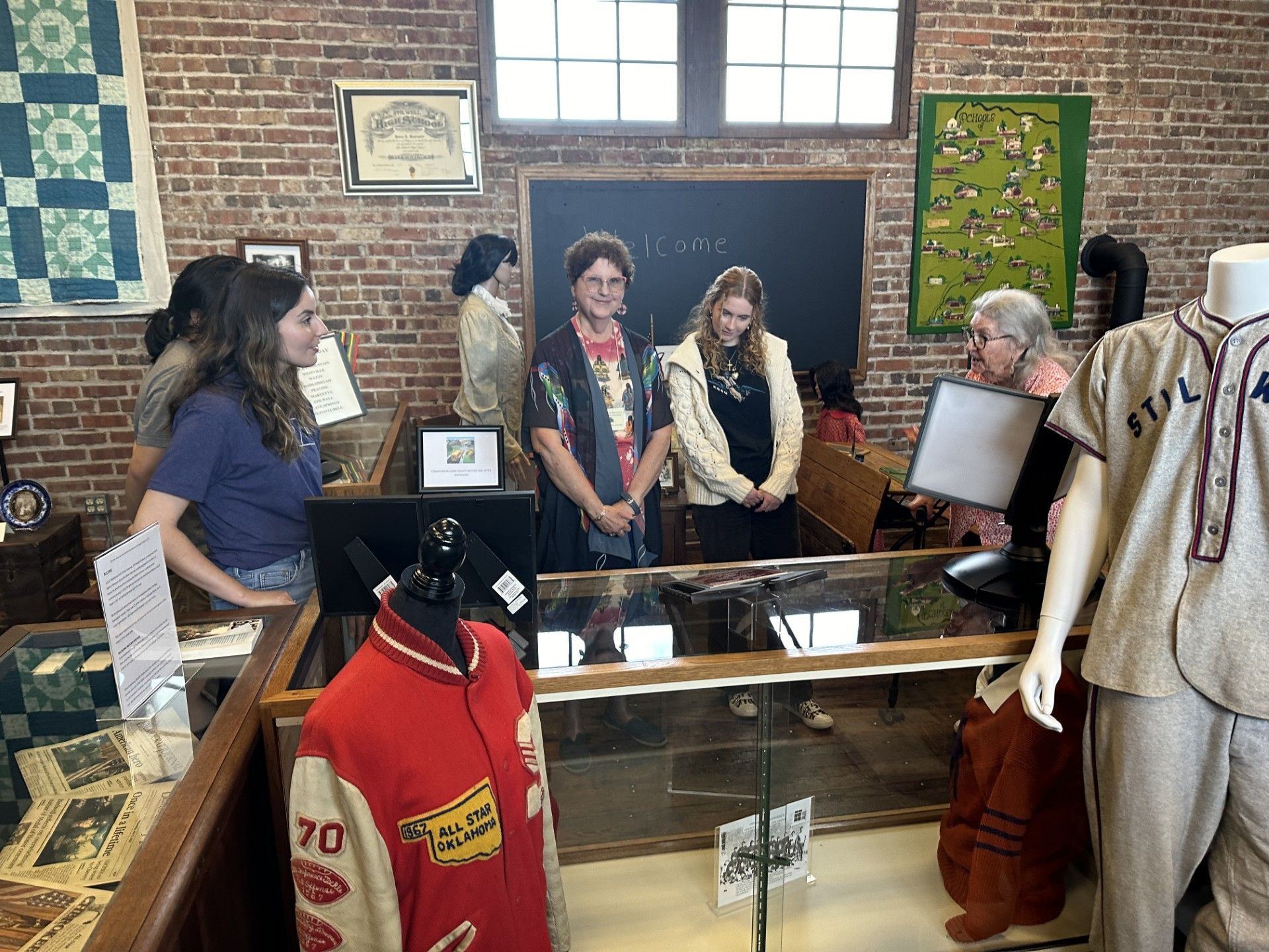 A group of people are standing around a display case in a museum.
