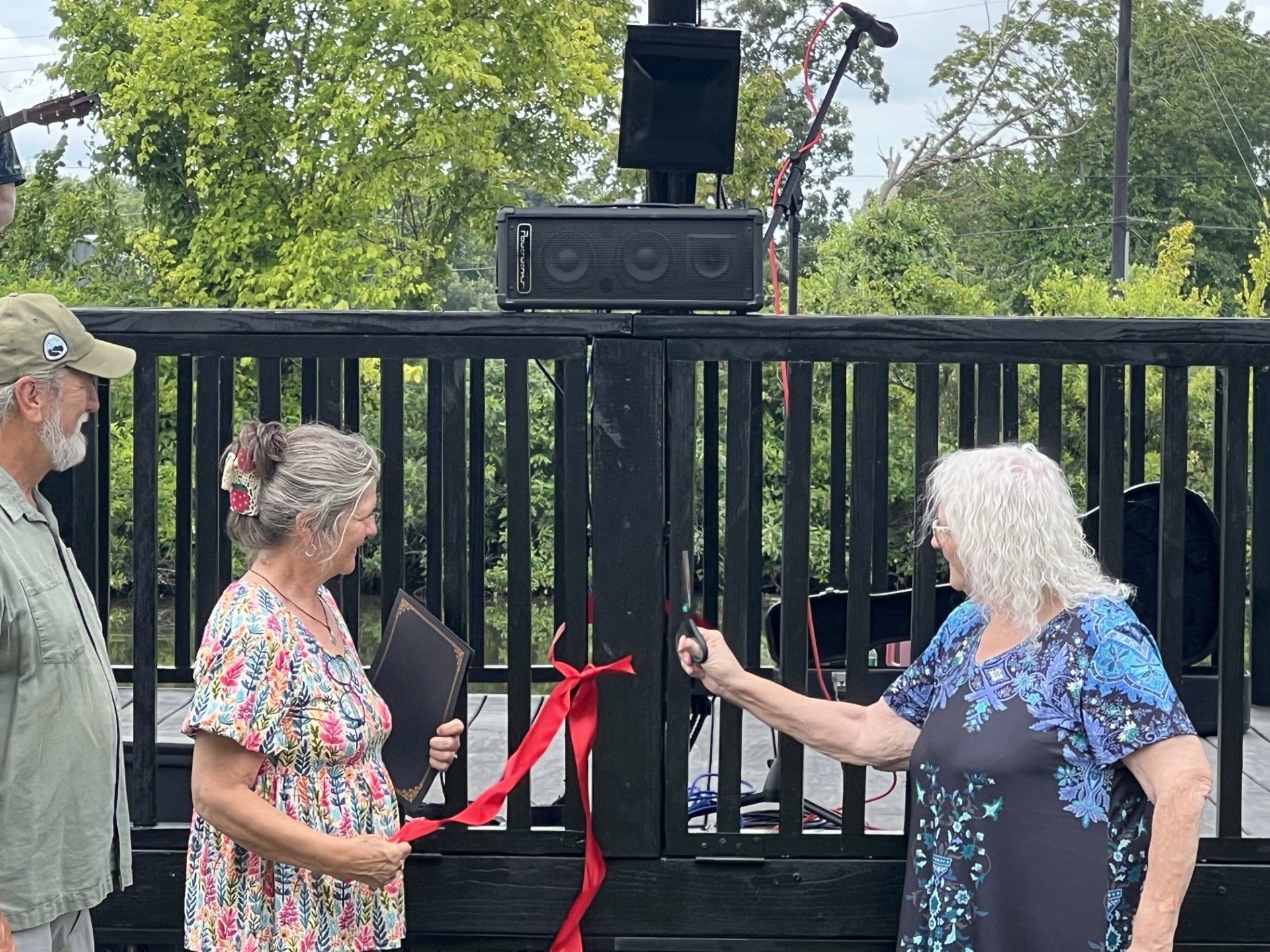 Stilwell Mayor Jean Wright cuts the ribbon with Shawna Duch and Bill Hill.