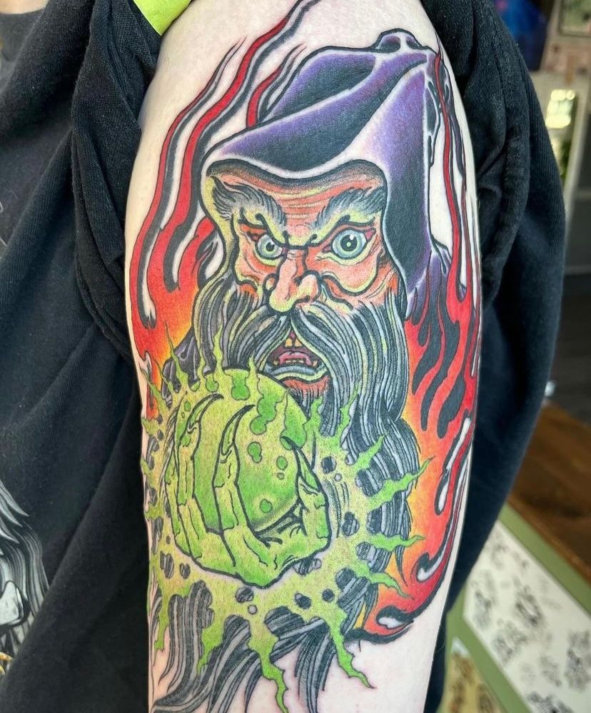 a tattoo of a man with a beard and a hat on his arm