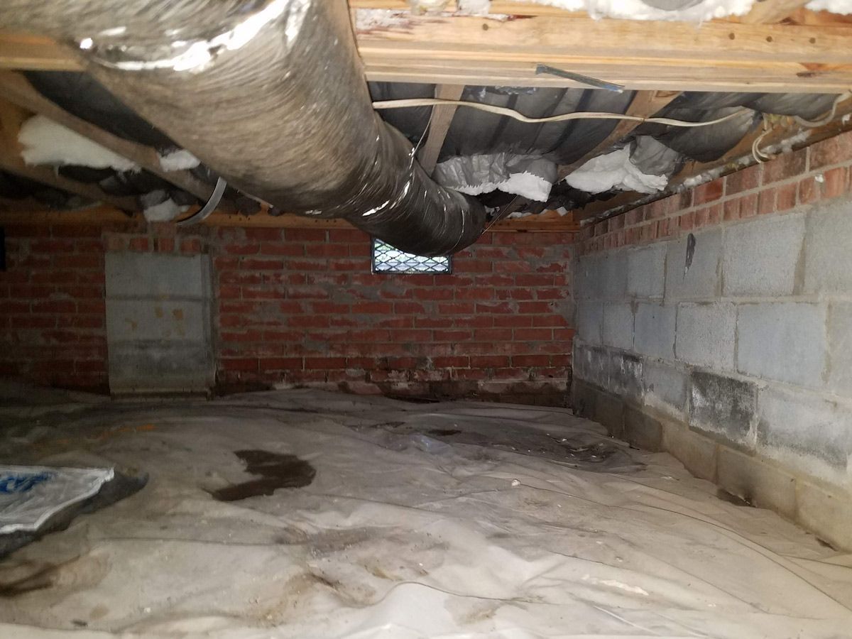 A damp crawl space with duct work.