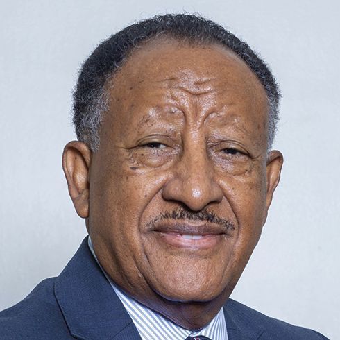 A man in a suit and tie is smiling for the camera.