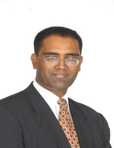 A man in a suit and tie is smiling for the camera
