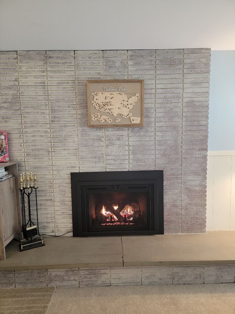 A fireplace with a map of the united states on the wall above it.