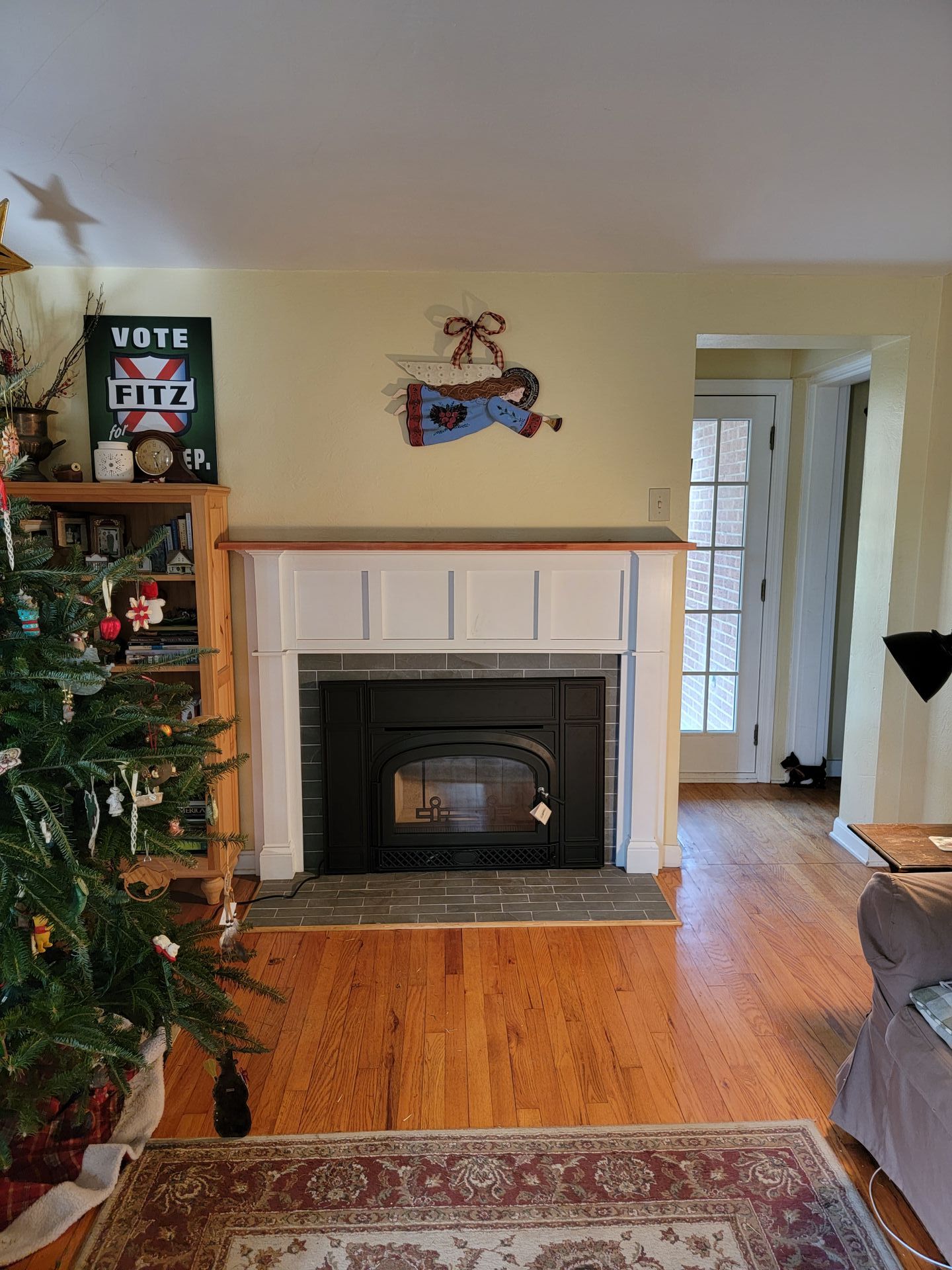 A living room with a fireplace and a christmas tree.
