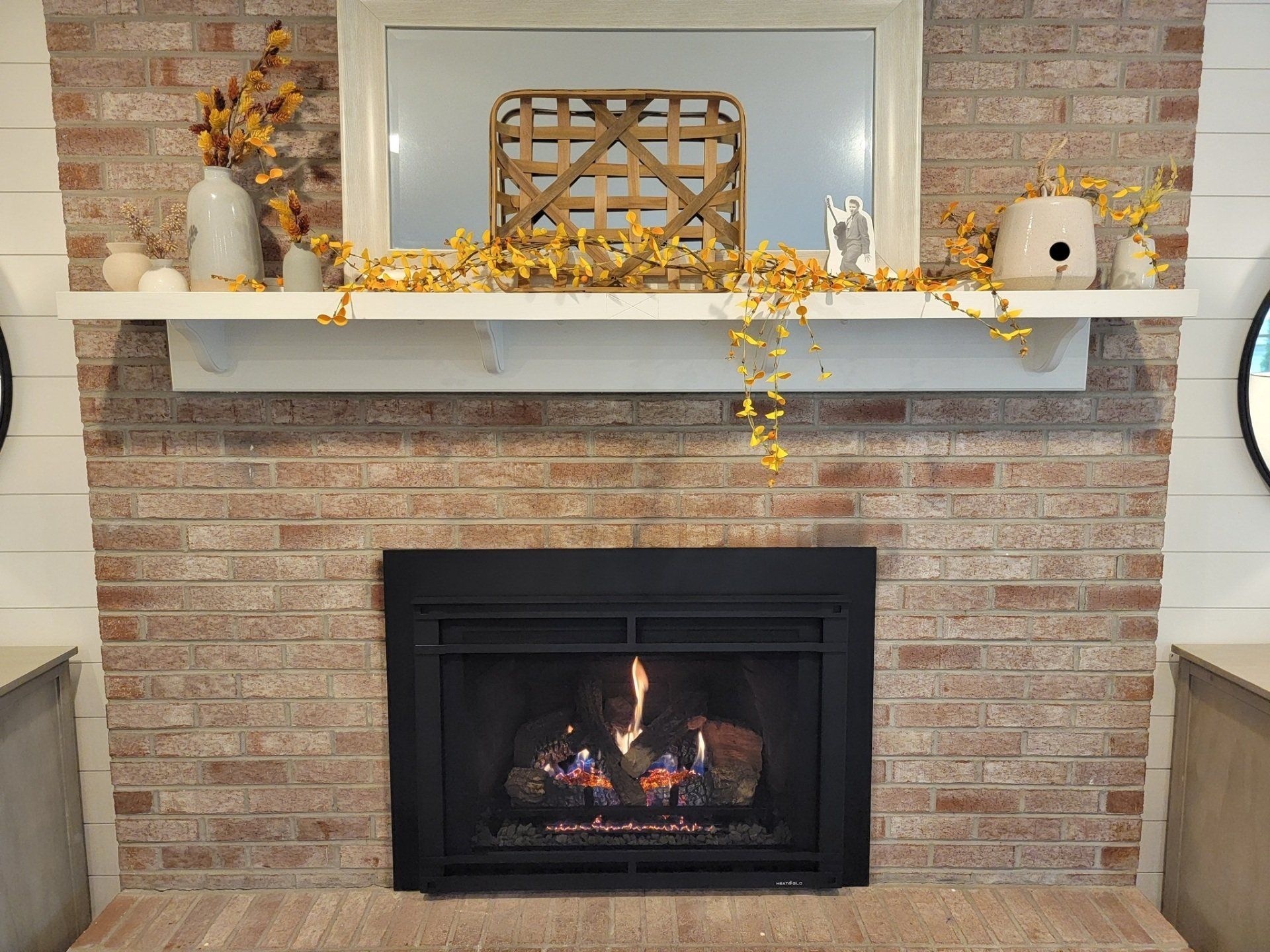 A fireplace with a mantle and a mirror in a living room.