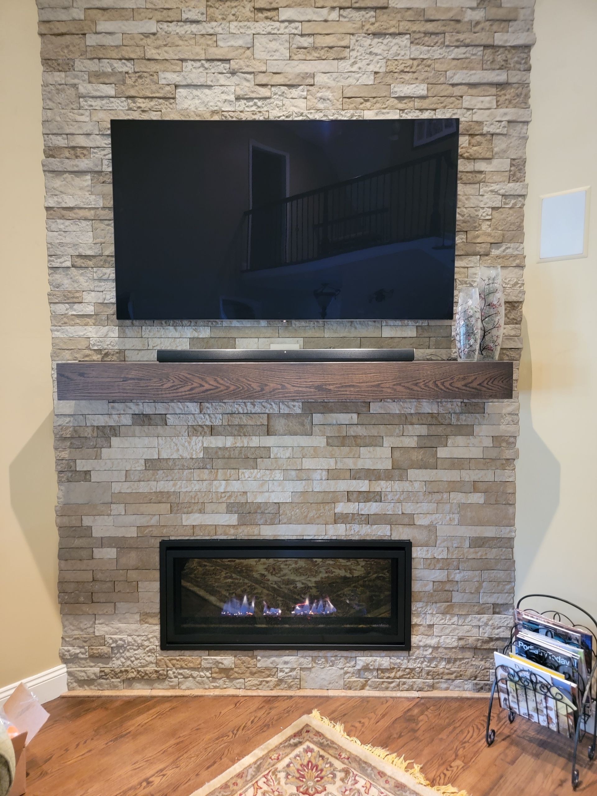 A living room with a fireplace and a flat screen tv on the wall.