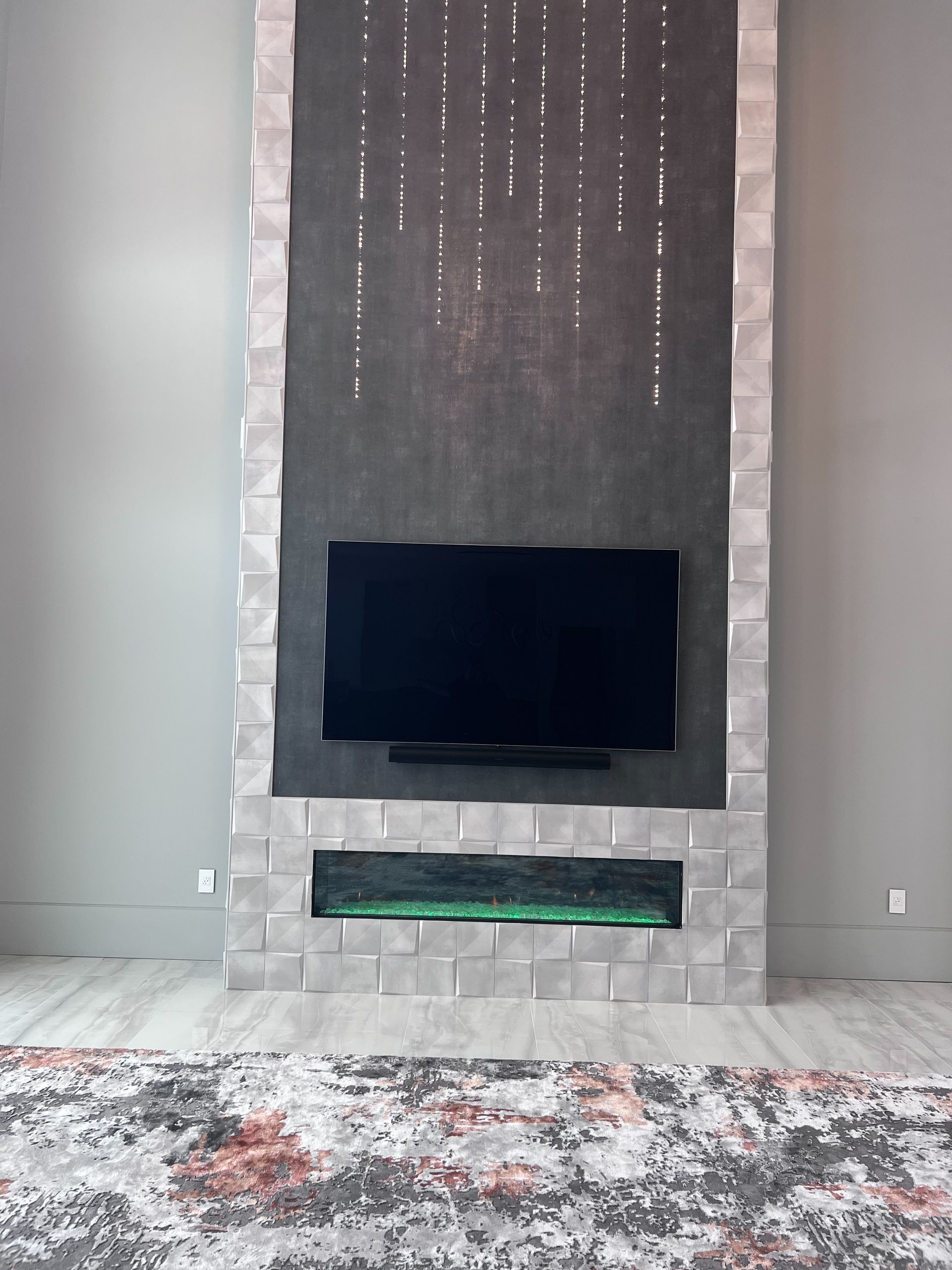 A living room with a fireplace and a flat screen tv on the wall.